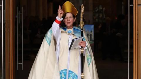 The Right Reverend Debbie Sellin makes the sign of the cross