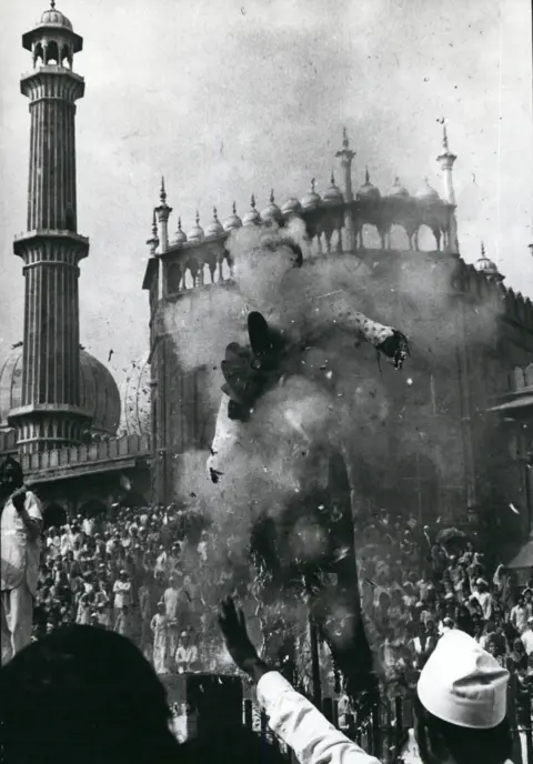 Alamy Demonstrators outside the Grand Mosque burn an effigy in protest against the building's seizure