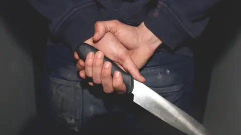 PA Media Teenager with knife in hand