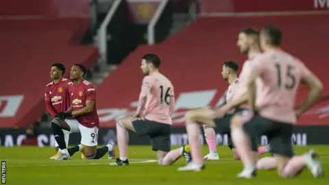 Manchester United and Sheffield United players kneeling before their Premier League game at Old Trafford