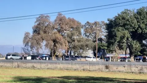 Police officers work next to emergency vehicles at the Feather River School of Seventh-Day Adventists, where a gunman shot and wounded two children aged 5 and 6 before shooting himself dead, near Oroville, in Palermo, California, U.S. December 4, 2024, in this screengrab obtained from social media video.