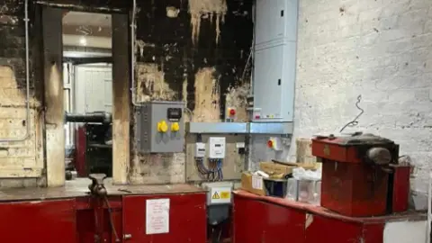 Redcar and Cleveland Borough Council Interior of the cliff lift engine room showing one newly painted wall alongside one with fire damage evident