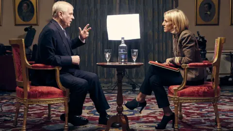 Andrew Mountbatten-Windsor sits in a suit, being interview by Emily Maitlis