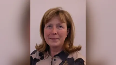 Oireachtas Oireachtas picture of Gillian Toole. She has strawberry blonde shoulder length hair curled at the bottom and a fringe. She is wearing a beige and black shirt and gold ball earrings.
