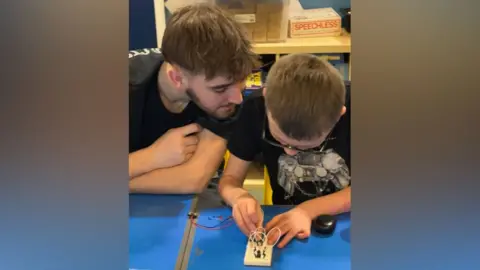 Lads Need Dads Charlie helping a boy with an electric circuit