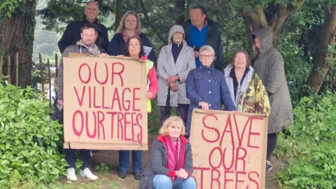 Ian Noel Wadhurst residents nestled among the trees with placards