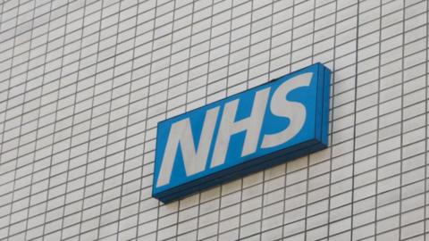The NHS logo on the side of a hospital