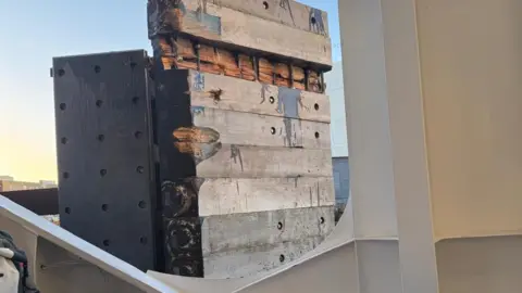 Roy King View from the bottom deck of a ferry looking out to the damaged quayside. The wooden berth is covered in scrapes with one of the timbers apparently missing.
