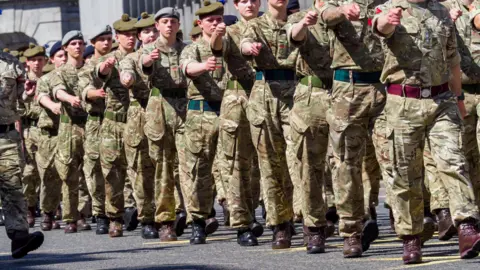 Soldier marching in formation along a street