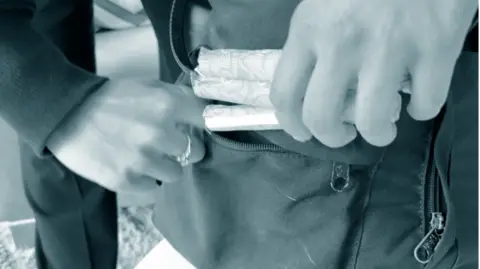 Lady putting sanitary products in a bag.