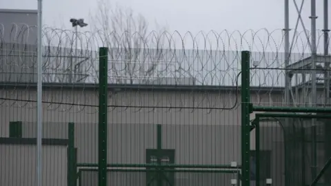 A barbed wire fence is pictured outside Campsfield Immigration Removal Centre. 