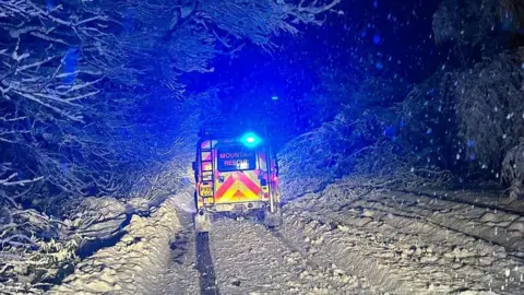 Wasdale Mountain Rescue A mountain rescue vehicle pictured from behind while going up a very snowy track at night