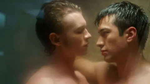 Sabrina Lantos/HBO Max Connor Storrie and Hudson Williams seen in a still from Heated Rivalry facing each other, head and shoulders, in a steamy shower scene.