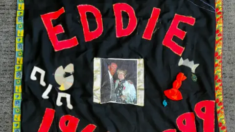 A black and red quilt comerating Eddie Boyne