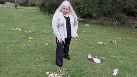 A woman with grey hair looking at flowers