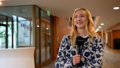 University of Kent Taylor Swift fan Elspeth Kennedy holding a microphone at a Taylor Swift conference