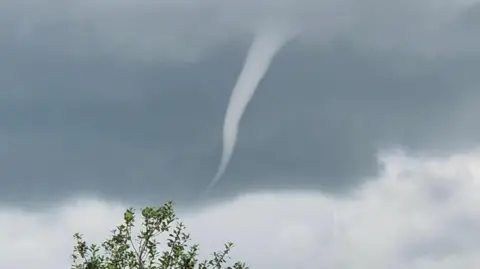moonking/BBC Weather Watchers A funnel cloud in the sky. It looks like a tornado.