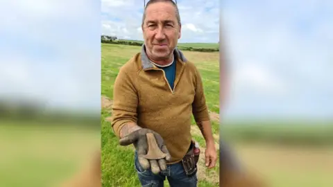 Oriel Môn Paul with the Bronze-age axe head he found