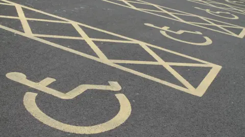 BBC A row of disabled parking spaces. The markings are yellow. 