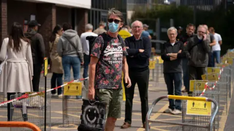 Getty Images Shoppers wqait outside B&Q store