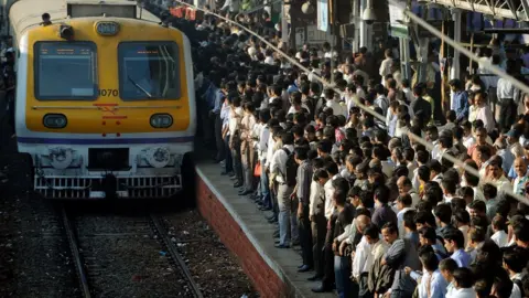 AFP Passengers wait to board a Mumbai local train