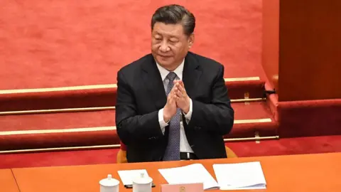 Getty Images China's President Xi Jinping applauds during the opening ceremony of the Chinese People's Political Consultative Conference (CPPCC) at the Great Hall of the People in Beijing on March 4, 2022.