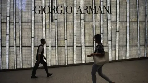 Getty Images People walking past a store of top Italian designer Giorgio Armani in Hong Kong