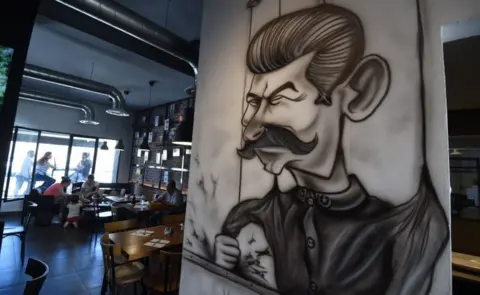 AFP Cartoons adorn the walls of restaurant "The Dictator" on July 5, 2017 in the upmarket Cite Ennasr suburb of Tunis. A steak named "Grilled Freedom" is just one of many dishes that stand out on the menu of the Tunisian capital"s "Le Dictateur" restaurant, not a favourite venue for the authorities. Six years after the country's revolution that sparked the Arab Spring, "Le Dictateur" vies for business.