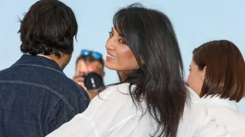 Getty Images Cannes film festival smiling for a picture. There are two people beside her.