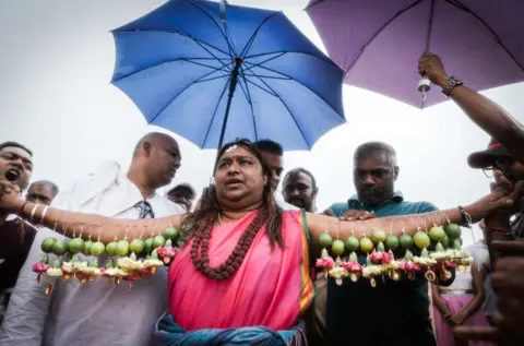 AFP A Hindu devotee gets her body hooked with spikes, lime, coconuts,fruits and flowers during the annual Hindu Thaipoosam Kavady festival held at Shree Emperumal Hindu Temple in Mount Edgecombe township, some 42 kms north of Durban on February 3, 2018