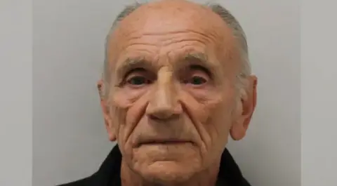 Avon and Somerset Police A mug shot of an elderly man who is balding. He has short, grey hair on the side of his head. 