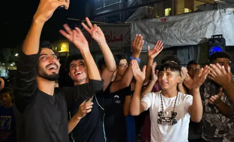 AFP vía Getty Images Palestinos celebran en una calle de Khan Younis tras el anuncio de Trump.