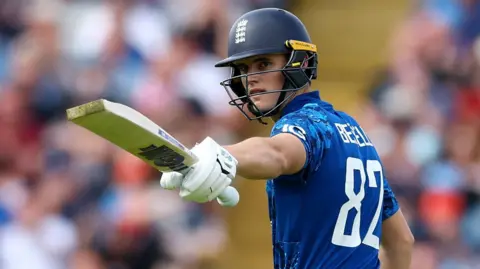 England batter Jacob Bethell raises his bat after hitting fifty