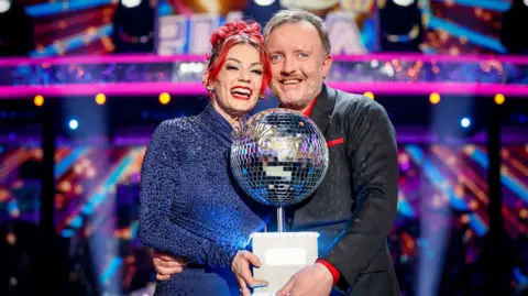 Dianne Buswell and Chris McCausland with the glitterball trophy