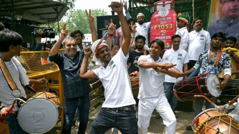 Getty Images Congress supporters celebrate in Delhi