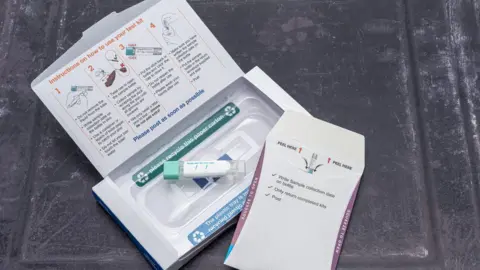 Getty Images An NHS bowel cancer home test kit. A small cardboard box has printed instructions on the inside of the lid about how to take a sample and return it 