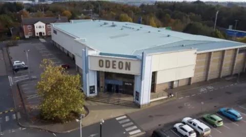 Kate Bradbrook/ BBC A drone shot of the Odeon cinema and its car park in Kettering