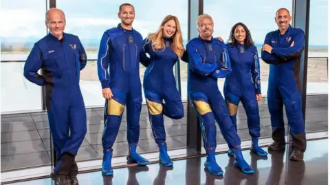 Virgin Galactic Colin Bennett, second from left, in his blue work uniform with his colleagues