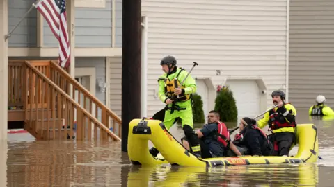 Reuters Rescue personnel use a yellow inflatable raft to evacuate Miguel Martinez and his sister, Epifani Martinez, who were stranded in their home in an area flooded by the Snohomish River, as an atmospheric river brings rain and flooding to the Pacific Northwest, in Snohomish, Washington, U.S., December 11.
