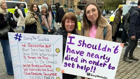 Rheanna Hazel  Rheanna Hazel with her mum at a march holding placards