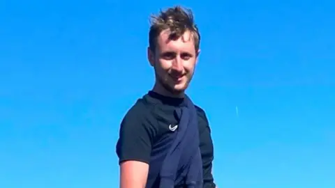 North Yorkshire Police A man in a dark t shirt stands with a blue sky in the background and hills