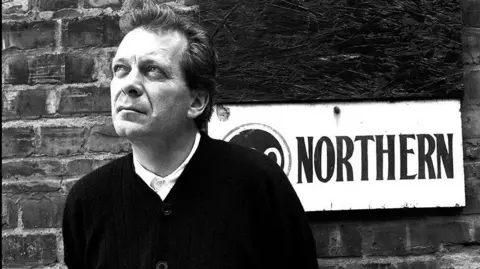 Paul Wolfgang Webster Photo of Tony Wilson stood under the sign, taken by Webster 