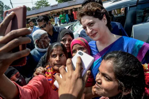 Getty Images Young women take a selfie with Priyanka Gandhi of the Congress Party during her election campaign on March 27, 2019 in Uttar Pradesh, India. 