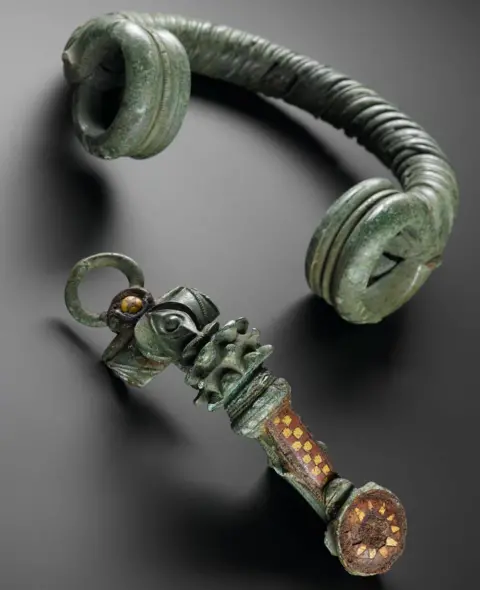 NMS A Roman period broach in green with some yellow and brown detailing