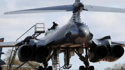 Reuters A member of the ground crew works on the top of a US Air Force B1 bomber, at RAF Fairford airbase, used by US Air Force personnel, amid the US–Israeli war with Iran, in Fairford, Gloucestershire.