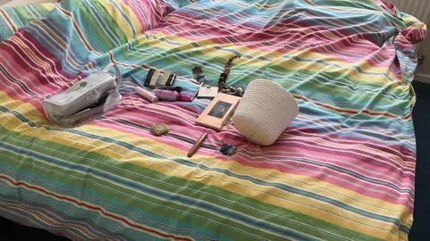 Amy Holmes/BBC Items on a bed 