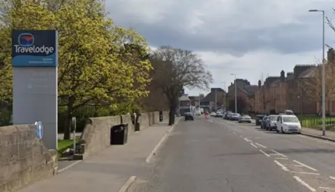 Google A main road with houses on one side and a Travelodge hotel on the other