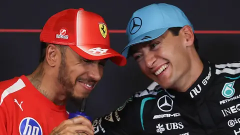 Lewis Hamilton and George Russell share a joke during the official news conference after qualifying for the Barcelona-Catalunya Grand Prix