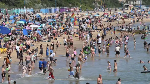 Getty Images Sunbathers and swimmers use the beaches in Bournemouth on the south coast of England