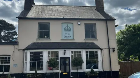 Julia Gregory / BBC A pub building with a sing on the front reading "The Crown".